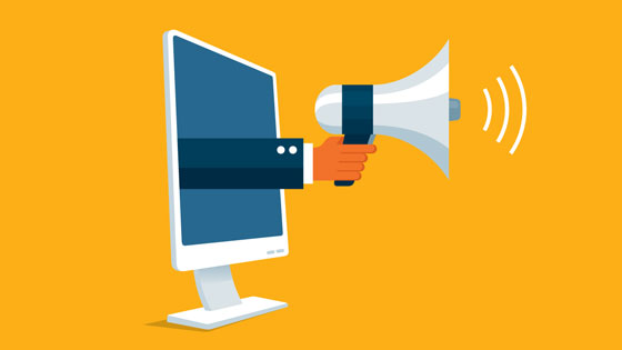 hand with megaphone coming through computer screen making an announcement 